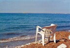 Una sedia di plastica sul golfo di Isola delle Femmine, in Sicilia, permette ai passanti di godersi in relax il rumore delle onde.
