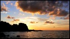 La foto ripoduce il momento del tramonto del sole dietro il Castello di Scilla