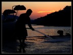 un pescatore lava il molo dopo aver pulito la rete per prepararla alla pesca