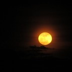 Era appena tramontato il sole a ovest quando ho visto spuntare la luna a est come una palla di fuoco, incendiata dal tramonto;  stato stupendo ....