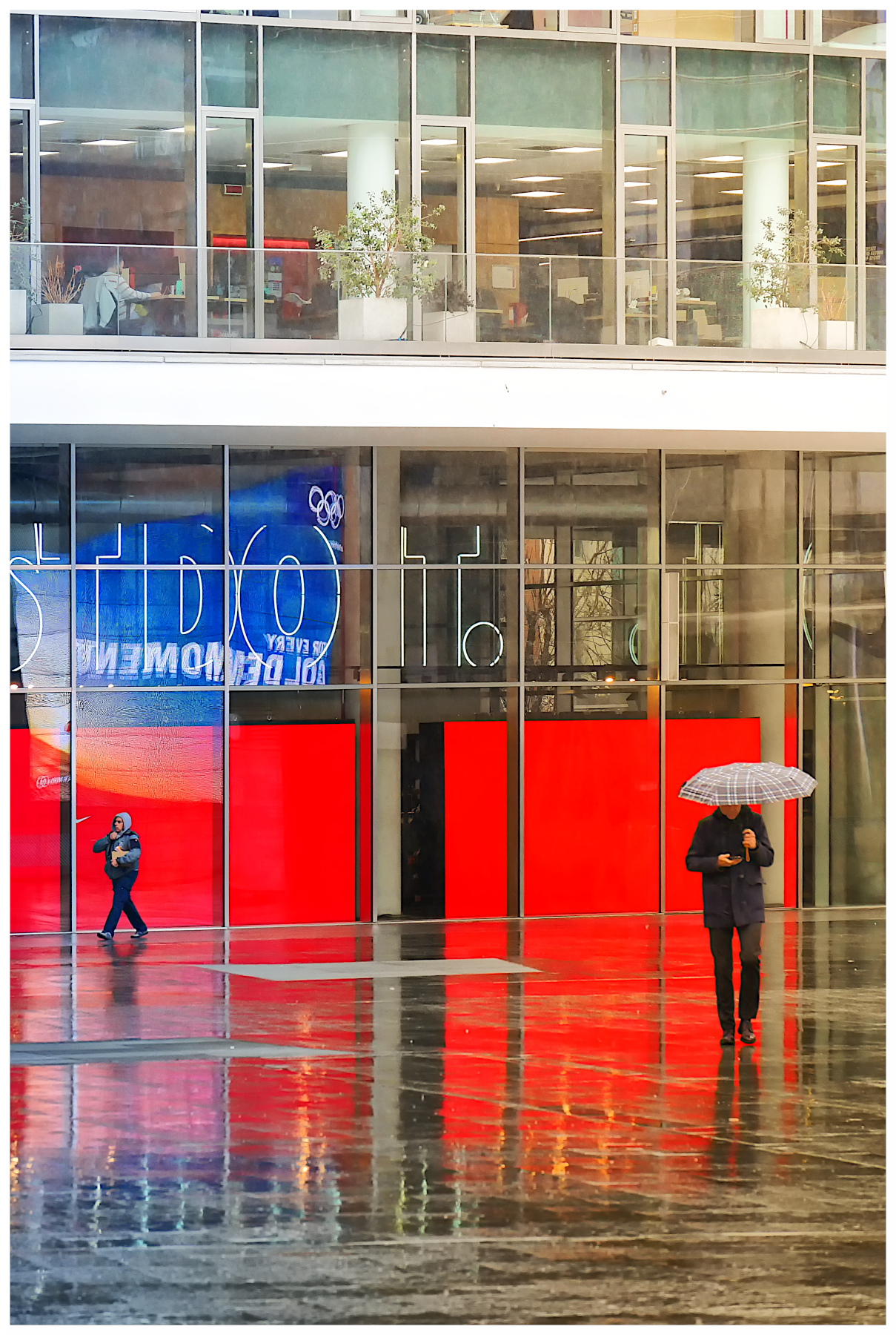 passanti in Piazza Gae Aulenti piovosa