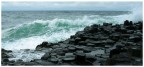 La rabbia dell'oceano a nord dell'irlanda si abbatte contro la scogliera di colonne scurissimie di basalto esagonale ...
