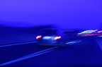 notturno di un'auto in corsa con il bilanciamento del bianco volutamente sfasato verso il blu