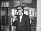 Umberto Baccolo davanti alla sua nota collezione di libri antichi