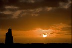 isola di sal,capoverde(marzo2009)...per l'ennesima volta il sole,prima di andare a dormire nell'oceano,saluta il suo amico faro che lo sostituira' con la sua luce intermittente per tutta la notte....