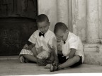 2 bambini che giocano con il riso in attesa che gli sposi escano dalla chiesa dopo la celebrazione del matrimonio
