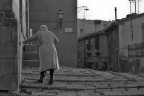 i segni del passato portati da questo borgo e l'anziana che lentamente va verso la chiesa
