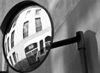Riflesso distorto in uno specchio stradale.