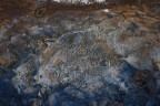 una concrezione in una pozza d'acqua. il ghiacchio nella parte bassa mostra qualche riflesso