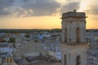 Campanile, torre dell'orologio e posteriore della facciata della chiesa di Melendugno. Con il sole che tramonta....