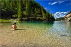 Una bambina gioca con le gelide acque del lago di Braies