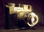 Macchina fotografica anni 60 made in Italy dalla Milanese Bencini (CMF) in alluminio pressofuso.
La fotocamera  una medio mezzo formato 30x45mm su pellicola 120 che permette di arrivare a scattare 24 fotografie.
Sul retro della fotocamera sono presenti due finestrelle contapose, quando si usa, bisogna far comparire il numero nella prima finestrella, scattare e far avanzare la pellicola fino a quando il numero che era presente a sinistra compare nella finestrella di destra, e cos via.