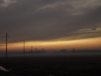 Campagna al tramonto con pali della luce