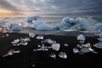 Alle prime luci del giorno, la forza dell'oceano si scaglia con forza contro gli iceberg e i ghiacci arenati lungo la costa.