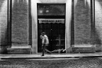 clochard che dorme sul ciglio del negozio di articoli religiosi