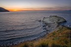 Agropoli (Sa) - Lo scoglio della baia di Trentova al tramonto; sullo sfondo Capri e la costiera amalfitana