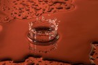 Goccia esplosa sopra una superficie bagnata