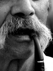 un uomo con la mania dei baffi e della pipa